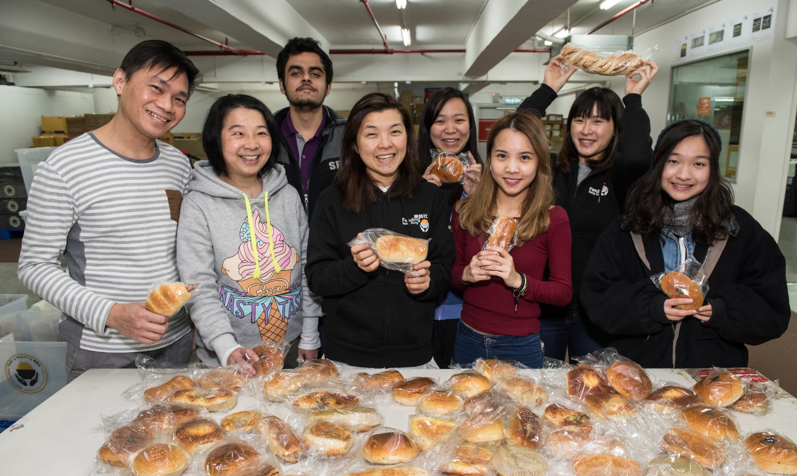 Volunteers sorting food parcels and preparing community donations in a bright kitchen, Julia M Cameron on Pexels.